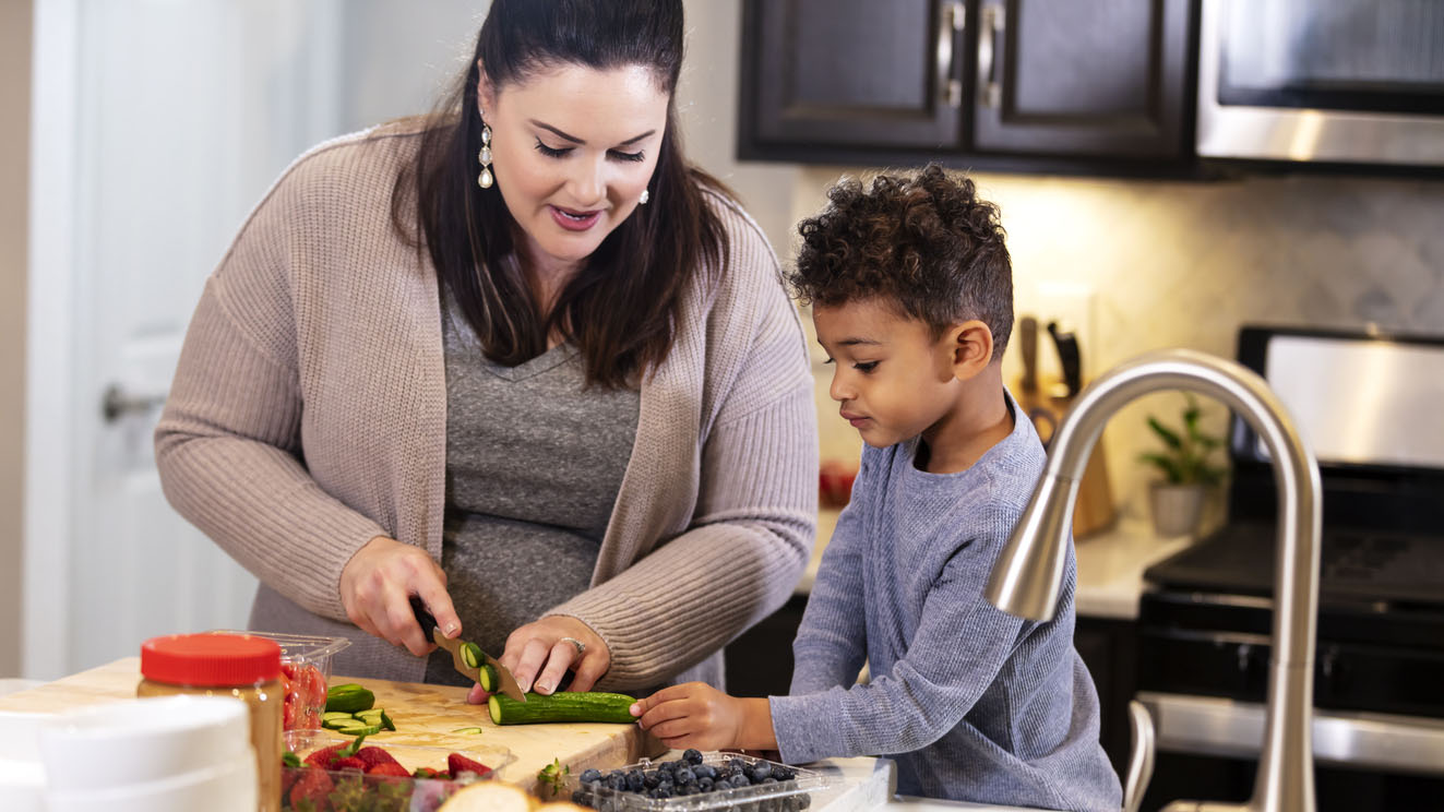 Mother and young son preparing vegetables in kitchen Mother and young son preparing vegetables in the kitchen